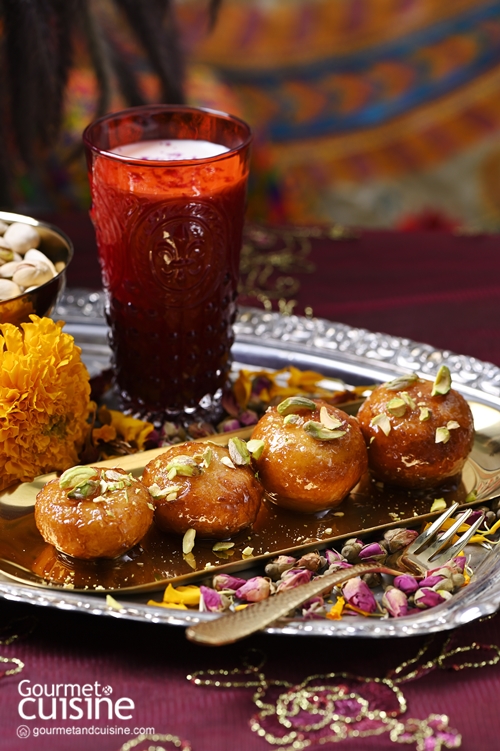 ป้าเจี๊ยบชอบอินเดียค่ะ กลับจากแสวงบุญ 4 สังเวชนียสถานแบบเดินทางสะดวก กินอร่อย นอนหลับสบาย อิ่มบุญกลับมาพร้อมด้วยวัตถุดิบทำอาหาร เวลาผ่านมาหลายเดือนสิ่งที่หมดไปแล้วคือไมด้า (Maida) แป้งสาลีอินเดีย ต้องสั่งออนไลน์มาอีกหลายรอบ เพราะน้องแพรและพี่มาร์ค หวานใจของน้องแพรชอบกินโรตีกับแกงผักโขม Palak Paneer  เดือนหน้าป้าเจี๊ยบจะไปอีก คราวนี้ขึ้นเหนือ เป้าหมายคือหิมาจัล สวิตเซอร์แลนด์ของอินเดีย ขากลับคงมีของมาทำกินแน่นกระเป๋า...ฮา  ของหวานยอดนิยมที่ป้าเจี๊ยบพบแทบทุกมื้อระหว่างอยู่ในอินเดียและเนปาลคือกุหลาบจามุน (Gulab Jamun) แต่ละที่มีกลิ่น รส เนื้อสัมผัสแตกต่างกันไป เหมือนกันอย่างเดียวคือหวาน  ป้าเจี๊ยบชิมแล้วก็ชอบนะคะ แต่คิดว่าถ้าลดหวานลงและเหยาะเกลือนิดให้กลมกล่อมน่าจะถูกปากหญิงไทยคนนี้มากกว่า ฉะนั้นทำกินเองแบบที่ตัวเองชอบสิ และจะตั้งชื่อว่ามาลัยกุหลาบจามุน ขออภัยเพื่อนชาวอินเดียด้วยนะคะที่ทำแบบนี้  ครั้งนี้ป้าเจี๊ยบจะได้ใช้หม้อเคลือบขนาดเล็กเส้นผ่าศูนย์กลางประมาณ 5 นิ้วที่ซื้อมา 3 ใบเพราะความน่ารักซะที ทำปริมาณน้อยแค่พอหายอยาก! เริ่มด้วยการทำมาลัย (Malai) ตามชื่อที่ตั้งไว้ โดยนำนมสดรสจืดแบบไขมันเต็มร้อย 250 กรัม คาร์ดามอม 1 ชิ้น เกลือหิมาลัยหนึ่งหยิบมือ ใส่หม้อใบที่หนึ่งแล้วยกขึ้นตั้งไฟกลาง พอเดือดลดไฟลงเป็นไฟกลางคนข้างอ่อน ใช้พายซิลิโคนคนอย่างสม่ำเสมอไปเรื่อยๆ อย่างใจเย็นจนน้ำระเหยออกไปกลายเป็นครีมนมข้นๆ ป้าเจี๊ยบใช้เวลาประมาณ 8 นาที วางพักไว้ให้เย็นตัวลง ถัดไปหม้อใบที่สองใส่น้ำเปล่า 3/4 ถ้วยตวง น้ำตาลทราย 1/2 ถ้วยตวง น้ำกุหลาบเข้มข้น 1 หยด นำไปตั้งไฟแรงจนเดือด คนให้น้ำตาลละลาย ใช้เวลาเคี่ยวประมาณ 5 นาที วางพักไว้  	จากนั้นนำหม้อใบแรกมาใส่แป้งไมด้า 1/4 ถ้วยตวง และโซเดียมไบคาร์บอเนต 1/8 ช้อนชา ใช้มือนวดส่วนผสมทั้งหมดจนเนื้อเนียน แบ่งแป้งเป็น 5 ส่วนเท่ากัน ปั้นเป็นลูกกลมๆ แล้วใช้หัวแม่มือกดตรงกลางให้บุ๋มลงคล้ายถ้วย  หม้อใบที่สามใส่กี (Ghee) สูงประมาณ 1 นิ้ว ยกขึ้นตั้งไฟกลาง พอกีร้อนปรับไฟลงให้อ่อน นำลูกแป้งที่ปั้นไว้ลงทอด ใช้ตะเกียบคอยพลิกไปมาจนลูกแป้งเปลี่ยนเป็นสีน้ำตาลเข้ม คีบใส่กระชอนแล้วเขย่าให้สะเด็ดน้ำมัน ใส่ลูกแป้งลงในหม้อใบที่สอง ยกหม้อใบที่สองไปตั้งไฟกลางจนเดือด ใช้เวลาประมาณ 5 นาที ปิดฝาวางพักไว้ 2 ชั่วโมง ทำมาลัยกุหลาบจามุนเสร็จก็ทอดกะหรี่ปั๊บไส้ไก่ที่ทำไว้ให้น้องแพร แล้วไลน์บอกว่าว่างเมื่อไหร่แวะมารับด้วย พอมาถึงกะหรี่ปั๊บหายวับไปทันที 2 ตัว แล้วหยิบถุงมาใส่ที่เหลือเอากลับบ้าน ป้าเจี๊ยบบอกกินคาวแล้วต้องกินหวาน ขอให้ชิมขนมที่ทำ น้องแพรถามว่า “อันที่แช่ในน้ำมันนี่หรือคะ” ป้าเจี๊ยบหัวเราะ รีบบอกว่าน้ำเชื่อมค่ะ ตักออกมาแล้วโรยหน้าด้วยถั่วพิสตาชิโอหั่น น้องแพรชิมแล้วบอกว่าอร่อยดี หอมอวลในปาก มองแล้วนึกว่าจะหวานมาก แต่ไม่หวานอย่างที่คิด สรุปว่า “มาลัยกุหลาบจามุน” ของป้าเจี๊ยบสอบผ่านฉลุย!